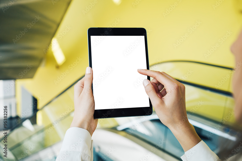 Blank tablet holding in woman hands on the blured background. Horizontal