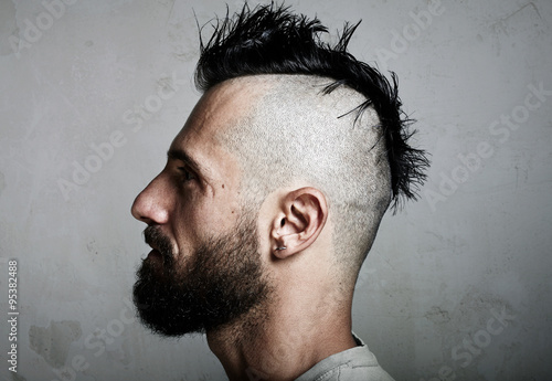 Konstfotografi Portrait of a bearded man with mohawk. Concrete background