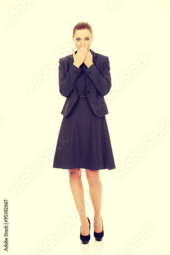 Businesswoman covering mouth with hands.