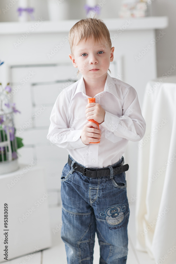 Beautiful happy blond boy holding a carrot Beautiful happy blond boy holding a carrot