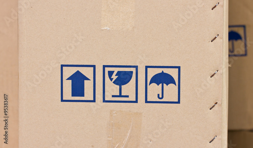 Safety, fragile icons on a cardboard parcel.