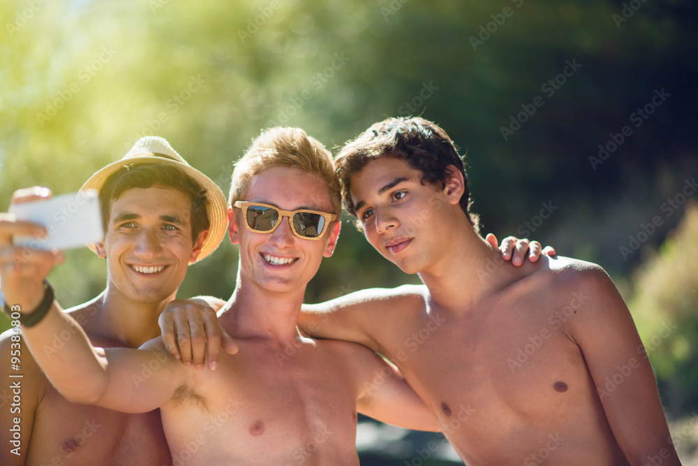 Fototapeta premium a young men with friends taking selfies on a smartphone 