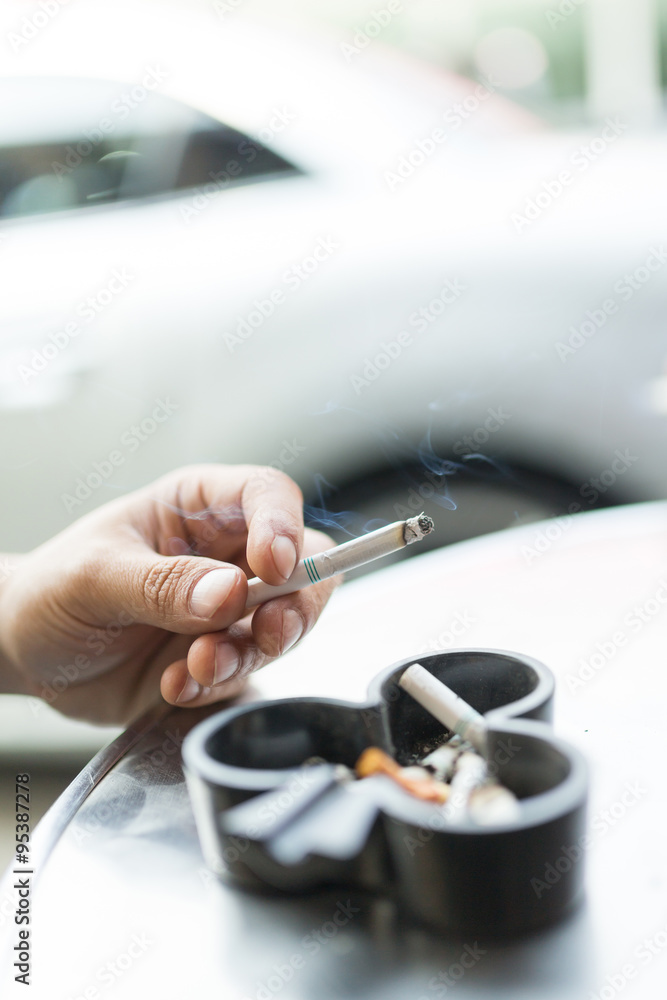 Man smoking cigarette and using an ashtray Man smoking cigarette and using an ashtray