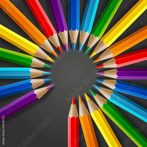 Circle of rainbow colored pencils with realistic shadow on dark grey background photo