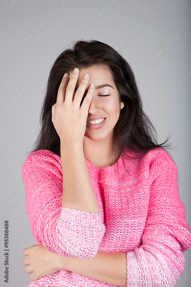 Young beautiful brunette woman in pink pullover palms her face tired. Young beautiful brunette woman in pink pullover palms her face tired.