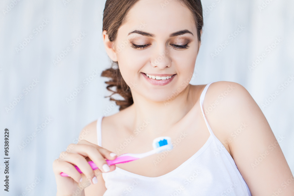 Beautiful smiling woman holding a toothbrush and toothpaste, fresh studio portrait Beautiful smiling woman holding a toothbrush and toothpaste, fresh studio portrait