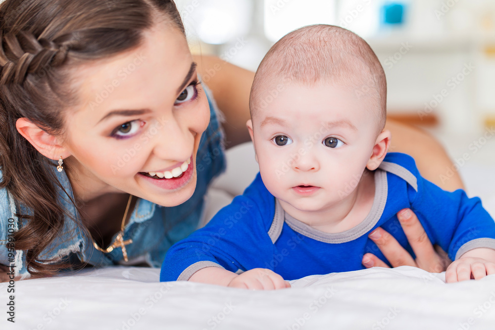 Happy family laughing faces, mother holding adorable child baby boy, smiling and hugging