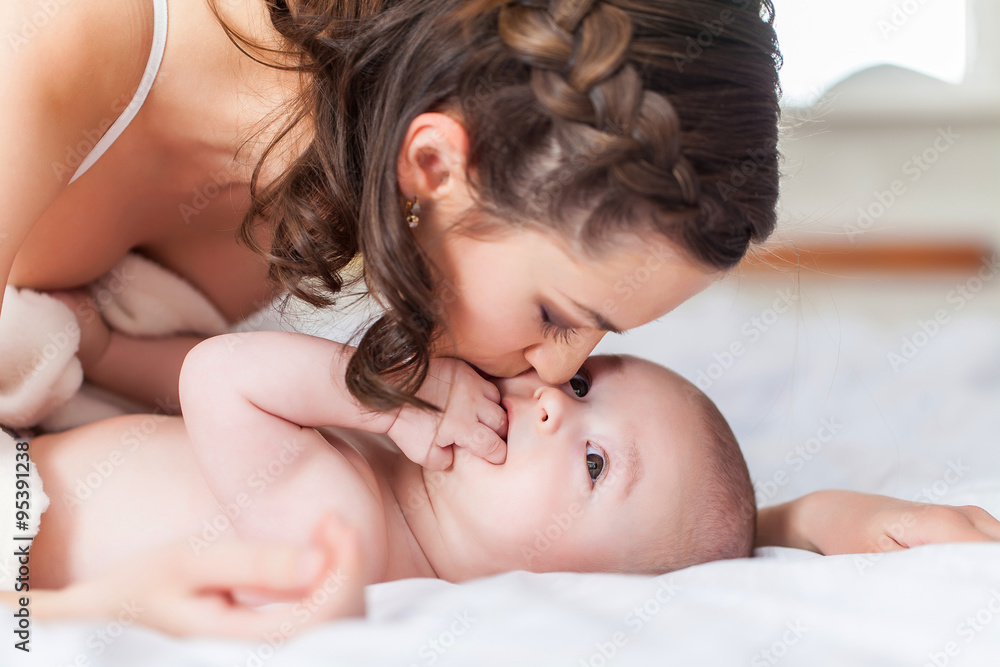 Happy family laughing faces, mother holding adorable child baby boy, smiling and hugging Happy family laughing faces, mother holding adorable child baby boy, smiling and hugging