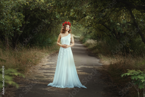 Fairy girl standing on the road in woods. photo