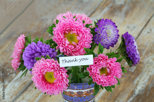 Thank you card with colorful bouquet of aster flowers on rustic wooden surface
