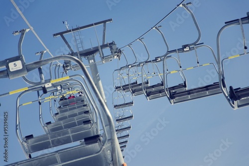 Filtered vintage photo of ski chair lift on sunny winter day