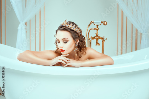 Cuadro en lienzo Beautiful naked young woman sitting in expensive jewelry bath.