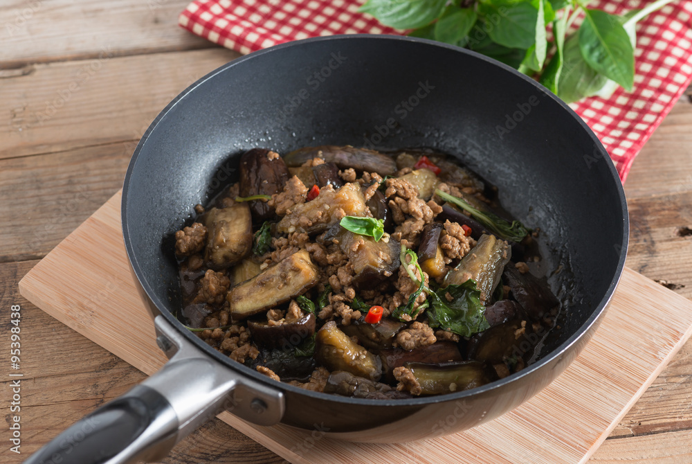 Stir fried eggplant with minced pork and basil in pan.