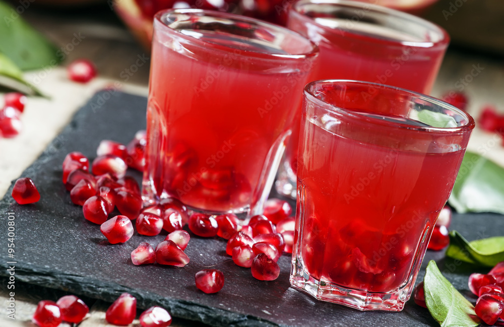 Fresh pomegranate juice on a black background, selective focus Fresh pomegranate juice on a black background, selective focus