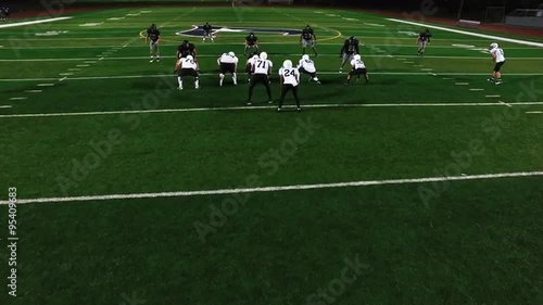 A football player gets tackled at the beginning of a play, view from above