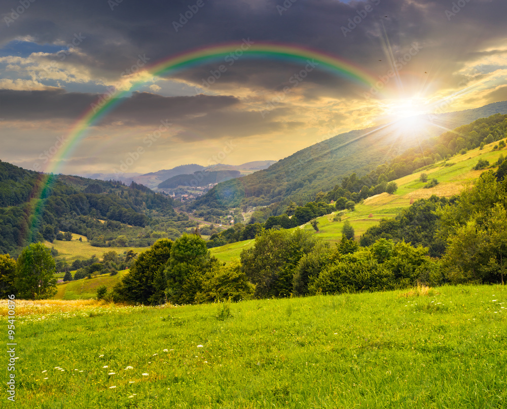 village on hillside meadow at sunset