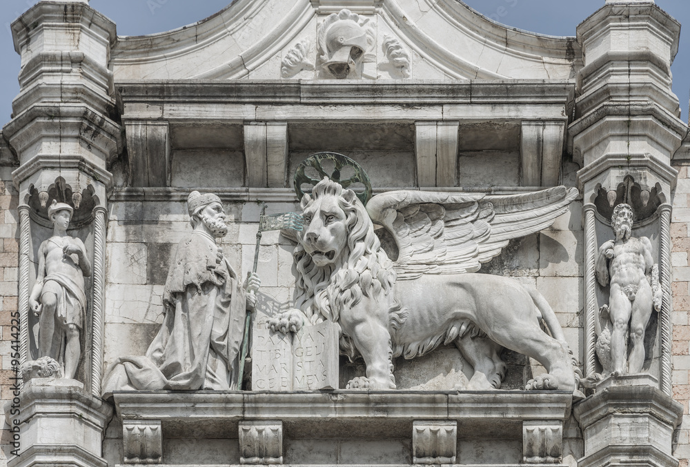 Sculpture of winged  lion of Venice with priest and book, Venice