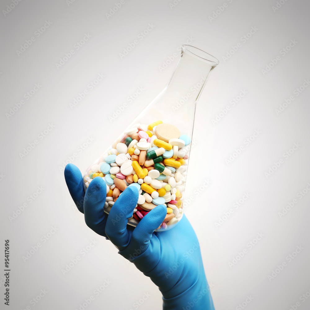 Obraz premium A lot of pills in the Erlenmeyer flask in the hand
