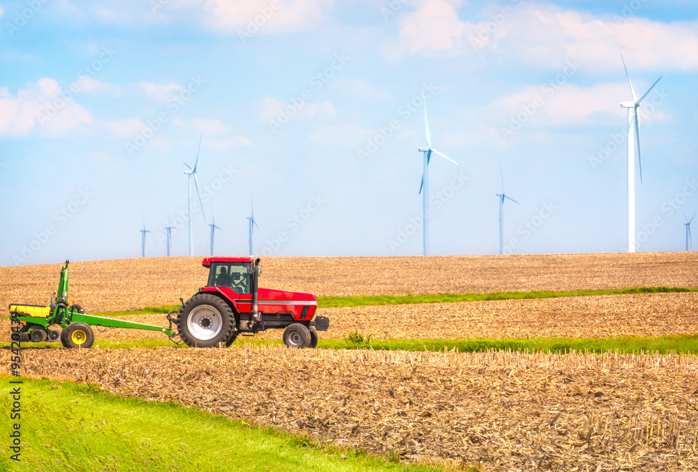 Obraz premium USA farmer farming with tractor on wind farm Danville Illinois