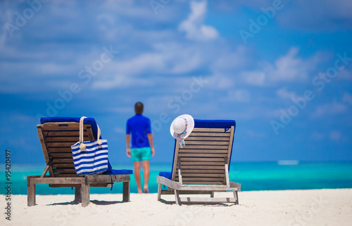 Young man on white beach duting tropical vacation in Indian ocean