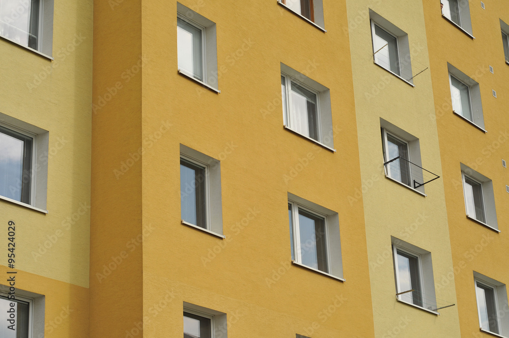 Pattern of apartment building windows on yellow wall.