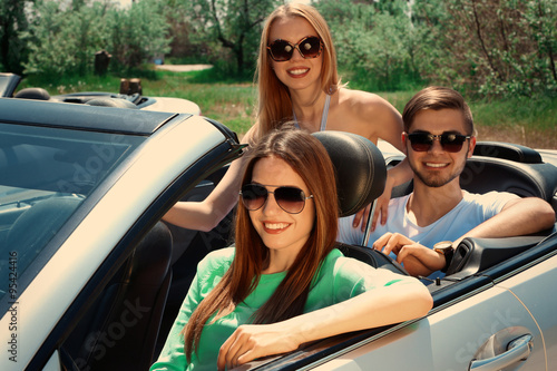 Three friends in cabriolet, outdoors © Africa Studio