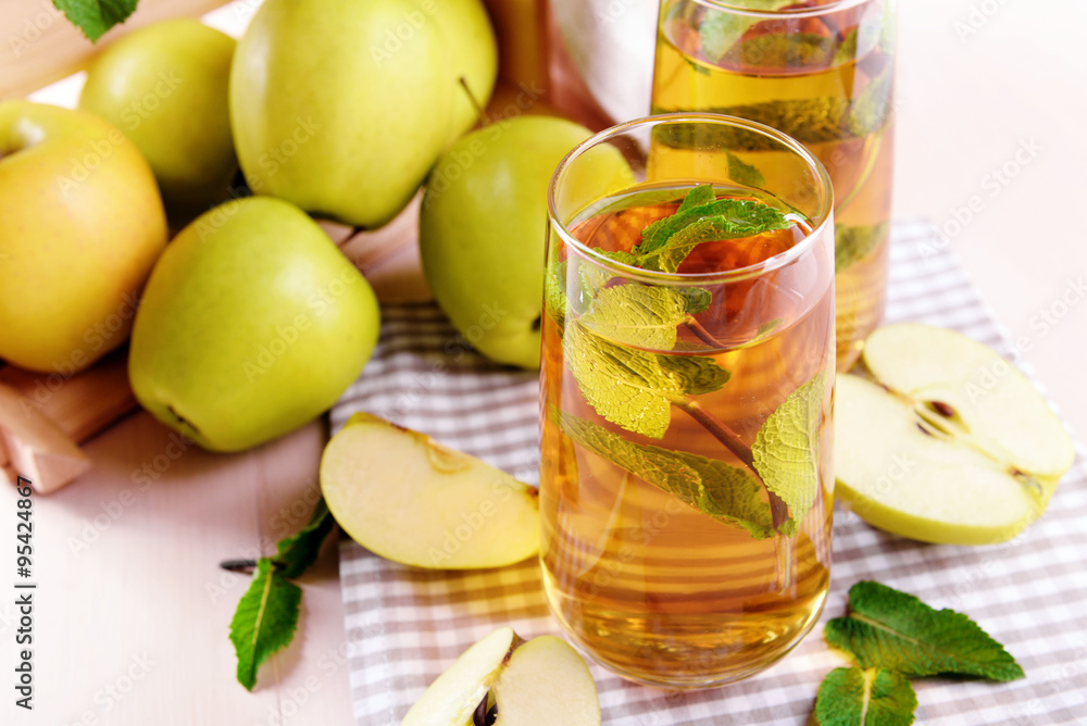 Glasses of apple juice with fruits and fresh mint on table close up Glasses of apple juice with fruits and fresh mint on table close up