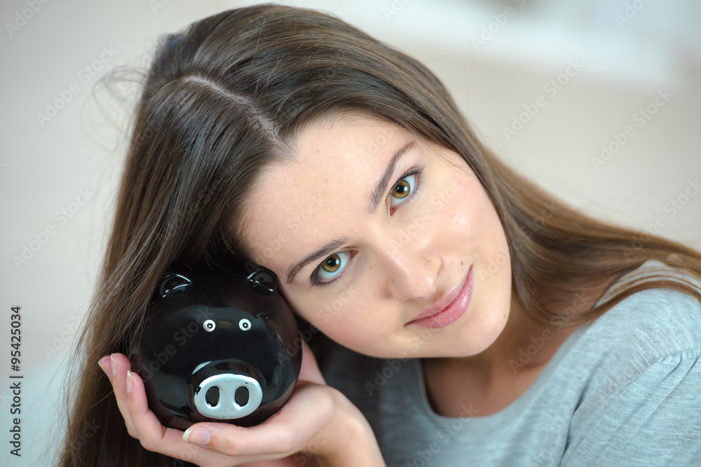 Fototapeta premium Smiling woman with piggy bank