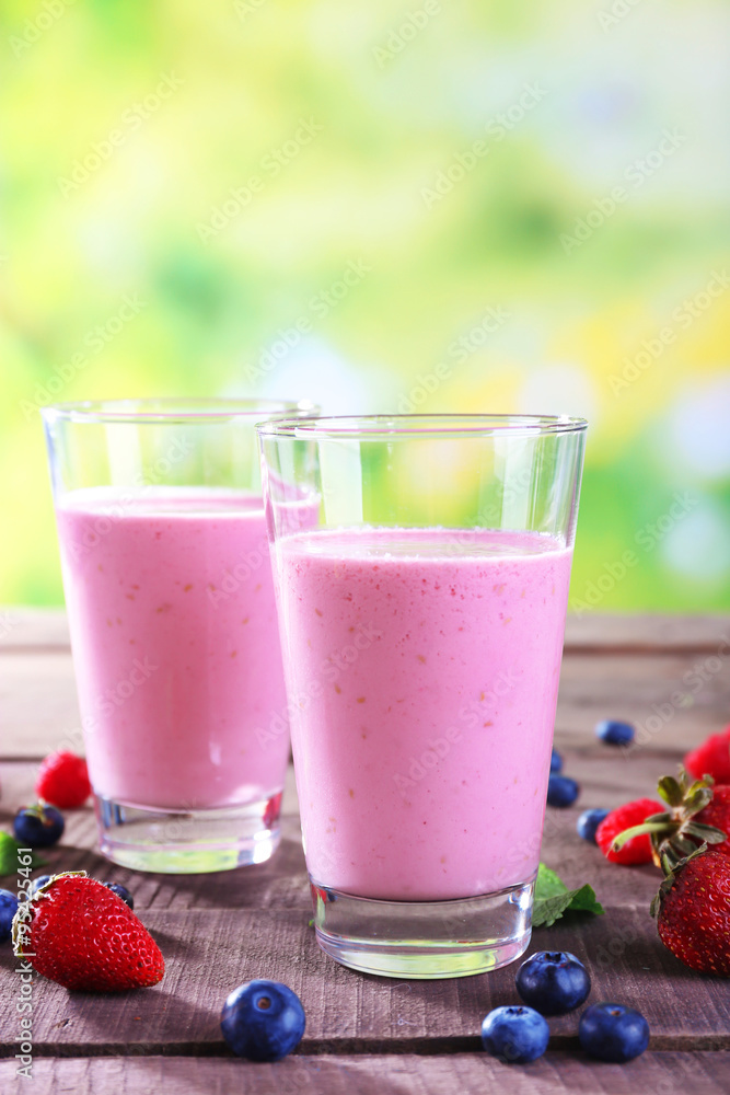 Glasses of berry smoothie on wooden table on blurred background Glasses of berry smoothie on wooden table on blurred background