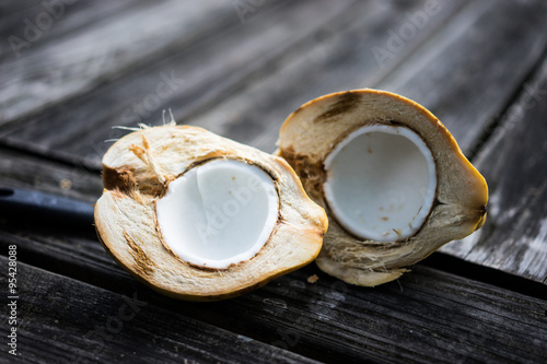 Halved coconut on wooden background