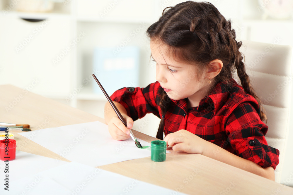 Cute little girl painting picture on home interior background Cute little girl painting picture on home interior background