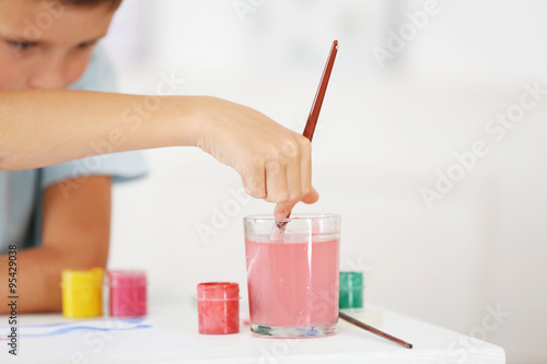 Cute little boy painting pi...