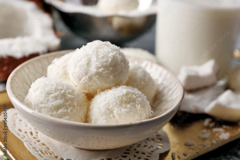 Homemade Candies in coconut flakes and fresh coconut on light background