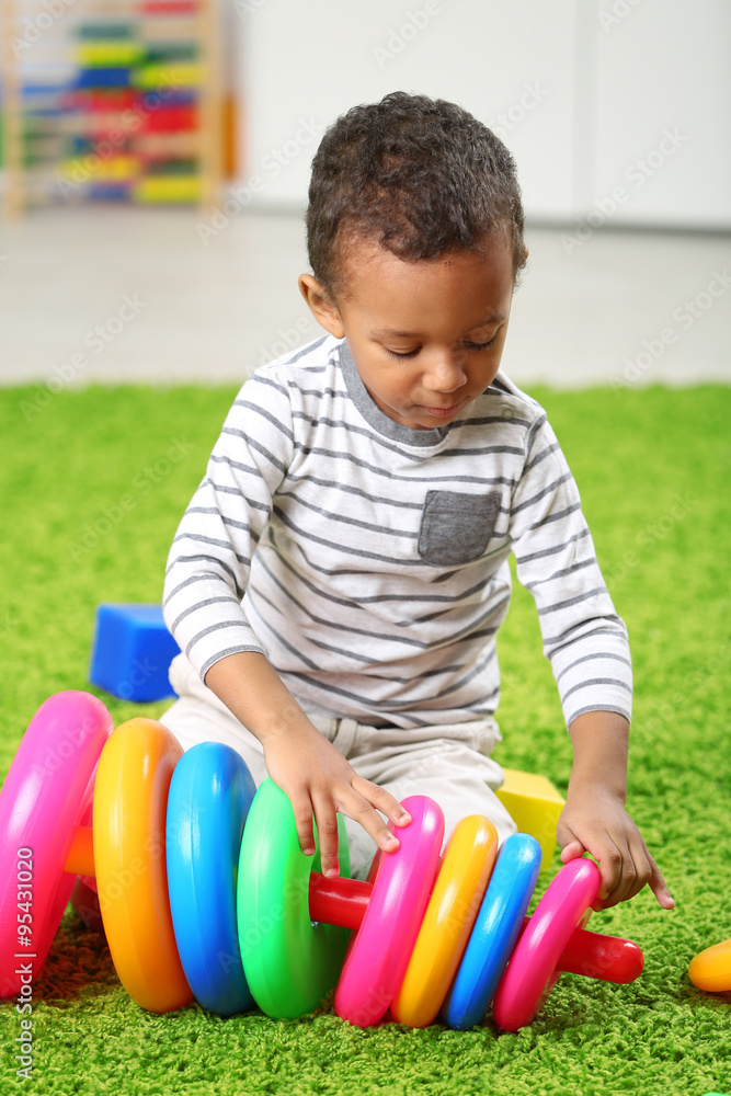 Obraz premium Little boy playing with his toys in the room