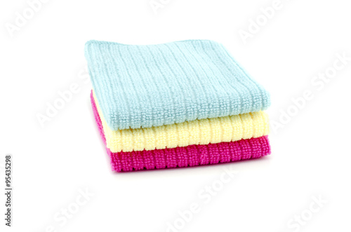 Pile of neatly folded colorful cotton towels in blue,yellow and red color isolated on white background