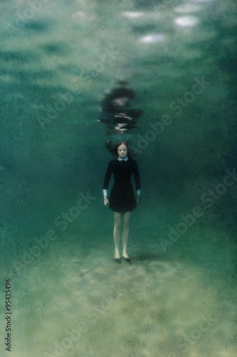 Girl in black dress underwater