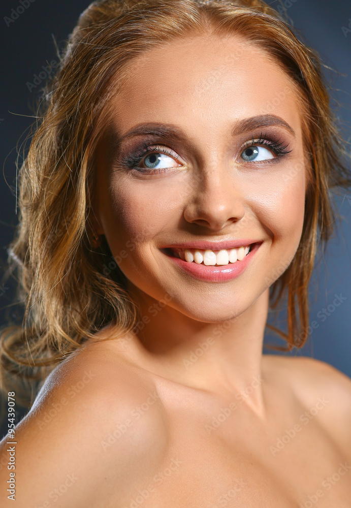Obraz premium Beautiful woman with curly long hair on dark background