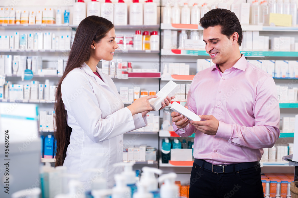 Pharmacist and consulting man in pharmacy