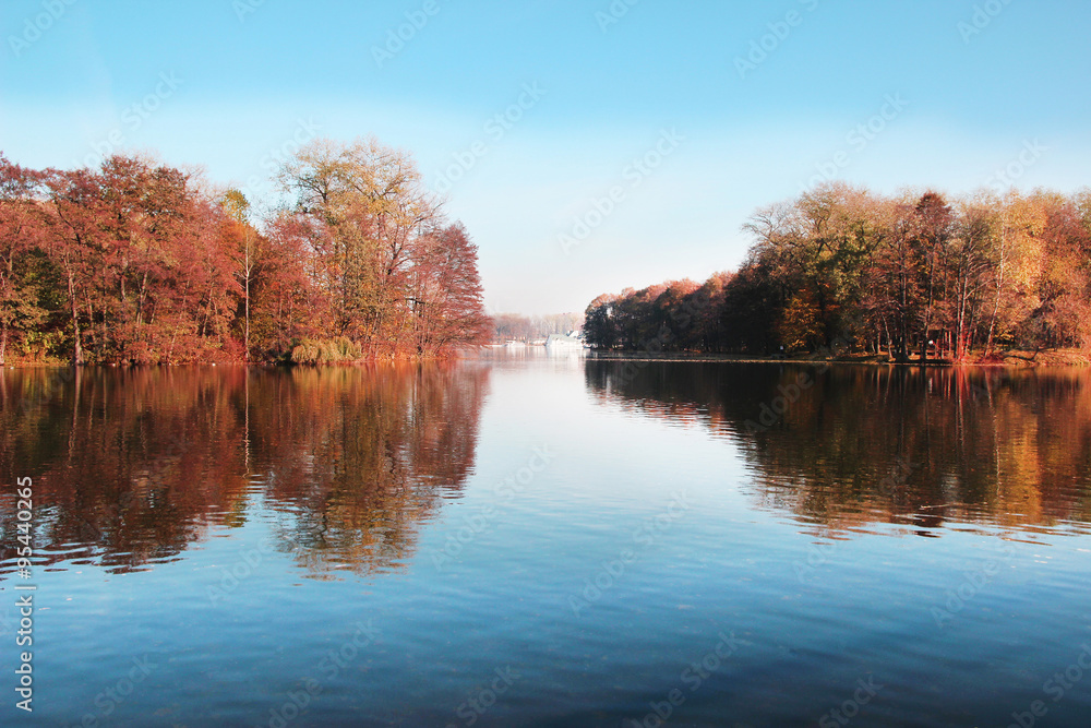 Beautiful autumn park. Autumn in Minsk. Autumn trees and leaves. Autumn Landscape.Park in Autumn. Mirror reflection of trees in water. Minsk city. Victory park in Minsk