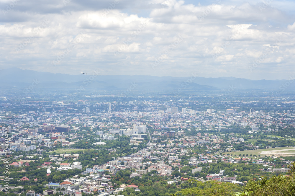 View of Chiang Mai city from a view point on Doi Suthep mountain as a plane takes off from Chiang Mai airport