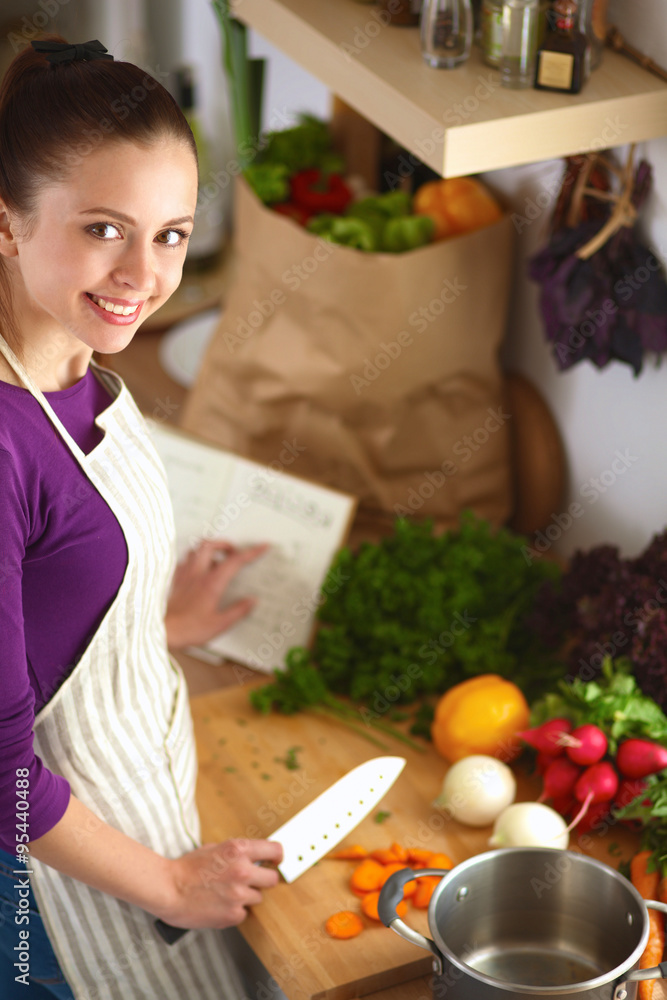 A young woman cooking in the kitchen. A young woman cooking in the kitchen.