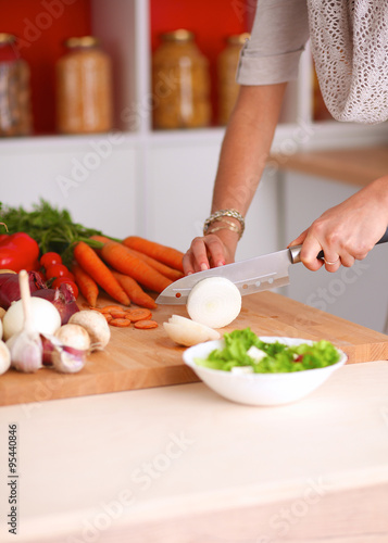 Fototapeta Naklejka Na Ścianę i Meble -  Young woman cutting vegetables in the kitchen