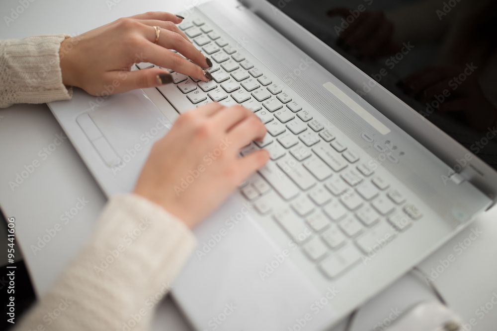 Girl's hands typing on a laptop in office Girl's hands typing on a laptop in office