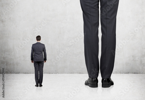 Fotografía Rear view of two professionals in formal suites who stand in front of concrete wall