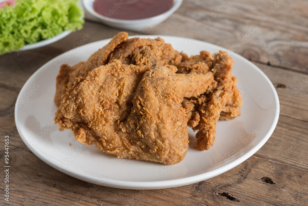 Fried chicken in white plate on a wood table. Fried chicken in white plate on a wood table.