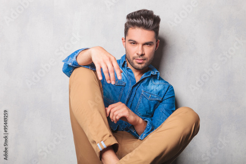 hansome man in denim shirt sitting in studio legs crossed