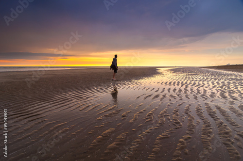 Canvas Print Young male at the beach during sunset