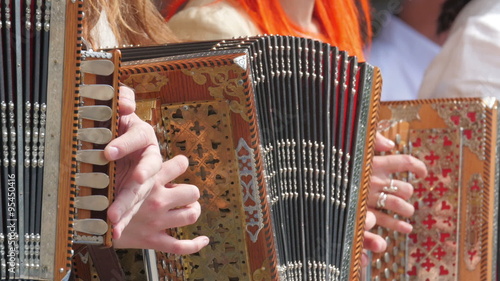 Accordion players are flipping their fingers on the instrument. Playing music on the concert photo