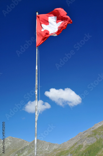 swiss national flag in the alps