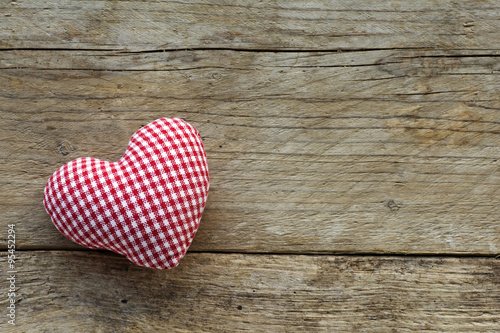 cloth heart with red white pattern on rustic old wood